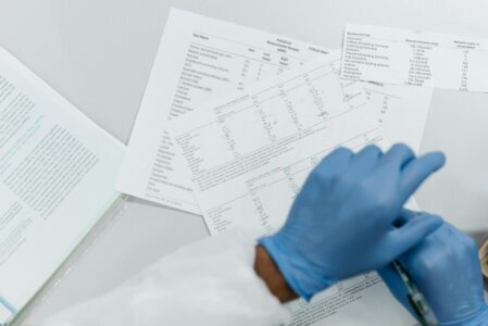 Lab reports and quality certificates displayed next to a bottle of extra virgin olive oil